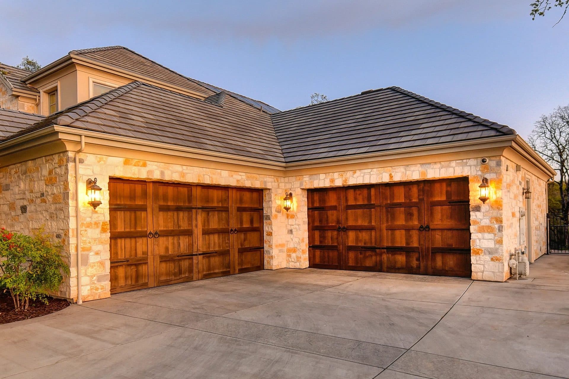 A luxury home with a custom hand-built wood garage door by Craft Doors USA